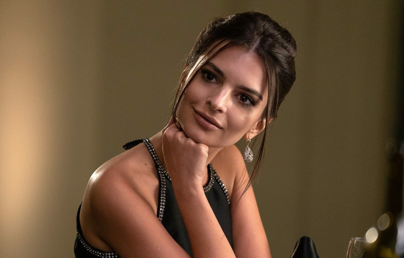 Photo d'Emily Ratajkowski en robe de soirée dans le film Arnaqueurs associés.